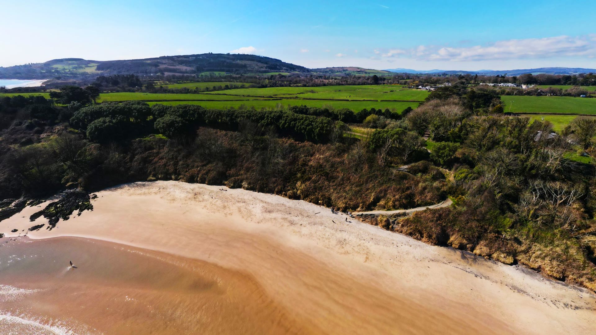 Aerial view of Magheramore Beach's golden cove and green cliffs, County Wicklow, Ireland — YouIn360 360° virtual tour